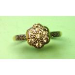 A Diamond Cluster Ring With seven diamonds in a flower form platinum setting, two old cut diamonds