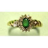 An Emerald and Diamond Cluster Ring Each shoulder set with three diamonds. In gold marked 375.