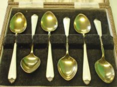 A Set of Six Silver Gilt Coffee Spoons Decorated in guilloche enamel with wild flowers. Cased.