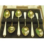 A Set of Six Silver Gilt Coffee Spoons Decorated in guilloche enamel with wild flowers. Cased.