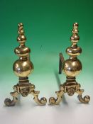 A Pair of Gilt Brass Fire Dogs Each applied with a lion mask and raised on scrolled supports.