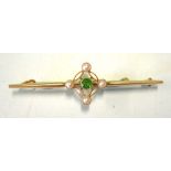 A Gold Bar Brooch. Set with a green stone and four split pearls. Marked 15ct. Condition report: