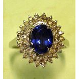 A Tanzanite and Diamond Cluster Ring With oval stone. In white gold marked 14K. Condition report: