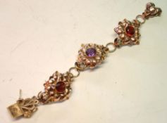 A 14ct Gold Bracelet Formed as three linked flower heads, set with an amethyst and two smoky