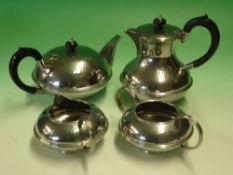 A "Speculum Plate" Tea Service Of hammered compressed form, comprising teapot, hot water pot, milk