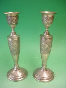 A Pair of Continental Silver Candlesticks With engraved foliate decoration to circular stepped foot,