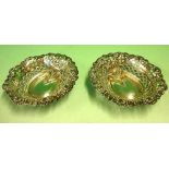A Pair of Silver Bonbon Dishes With embossed and pierced decoration. 3 ¾" wide. Birmingham 1904.
