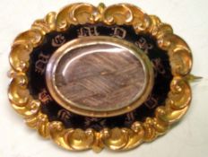 A Victorian Mourning Brooch Of Gothic revival form, with braided hair and enamel centre typically