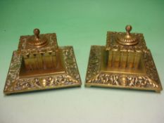 A Pair of Victorian Brass Inkwells Of square form and chased with scrolling foliage. 5 ¼" wide.