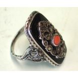 A Silver Dress Ring Set with a cabochon coral stone and cut steels on a jet table. Condition report: