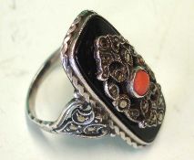 A Silver Dress Ring Set with a cabochon coral stone and cut steels on a jet table. Condition report: