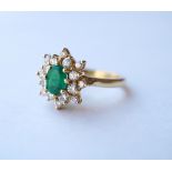 EMERALD AND DIAMOND CLUSTER RING
the central oval cut emerald approximately 0.