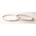 TWO NINE CARAT WHITE GOLD BANGLES
one with safety clasp weighing approximately 8.