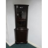 A PAIR OF MAHOGANY BOW FRONT CORNER CABINETS with astragal glazed doors the base with cupboard on