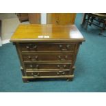 A GEORGIAN STYLE FOUR DRAWER CHEST with brass handles and quarter columns and bracket feet 58cm