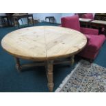 AN EDWARDIAN PINE BREAKFAST TABLE of circular outline the shaped moulded top raised on ring turned