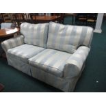 A TWO PIECE SUITE comprising of a two seater settee with loose cushions and scroll arms together