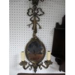 A PAIR OF BRASS GIRANDOLE MIRRORS each with a ribbon tied back plate above an oval plate issuing