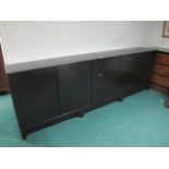 A LARGE EBONISED DESIGNER SIDE CABINET of rectangular form the shaped moulded top above three