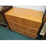 A SATIN BIRCH CHEST the rectangular top above an arrangement of eight drawers on cylindrical legs