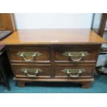 A HARDWOOD CHEST the rectangular top above four deep drawers with heavy brass handles on bracket