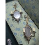 A PAIR OF BRASS GIRANDOLE MIRRORS each with a ribbon tied back plate above an oval plate issuing