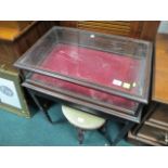 A MAHOGANY AND GLAZED DISPLAY CASE of rectangular form the shaped moulded top with glazed top and