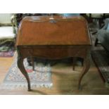 A CONTINENTAL KINGWOOD BUREAU of bombe outline the hinged slope containing tooled leather writing