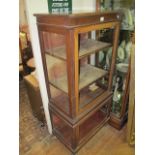 AN EDWARDIAN MAHOGANY DISPLAY CABINET with glazed doors between reeded pilasters on bun feet 150cm