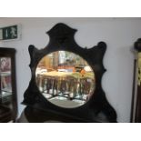 AN EDWARDIAN MAHOGANY OVERMANTLE MIRROR the oval bevelled plate within a moulded frame 100cm (h) x