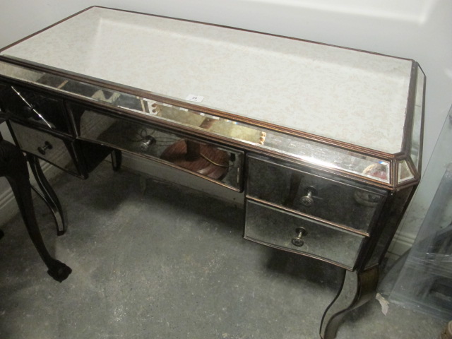 A MIRRORED SIDE TABLE the rectangular top above three frieze drawers on sabre legs 83cm (h) x 123cm