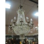 A CONTINENTAL GILT BRASS CUT GLASS TWELVE BRANCH BASKET CHANDELIER hung with cascading pendant