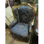 A CONTINENTAL GILTWOOD AND UPHOLSTERED WING CHAIR the serpentine top rail with foliate and