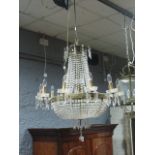 A CONTINENTAL GILT BRASS AND CUT GLASS BASKET CHANDELIER hung with cascading pendant drops and