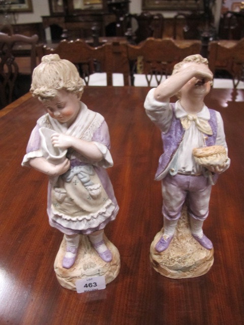 A PAIR OF BISQUE FIGURES modelled as a young girl and her companion she holding a conch shell he