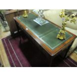 A MAHOGANY WRITING TABLE of rectangular outline the shaped moulded top with tooled leather insets