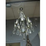 A CONTINENTAL GILT BRASS AND CUT GLASS SIX BRANCH CHANDELIER hung with faceted pendants