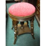 AN EDWARDIAN MAHOGANY STOOL the circular upholstered seat raised on turned legs joined by an under