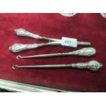 TWO SILVER HANDLE BUTTON HOOKS together with a silver handle curling tongs