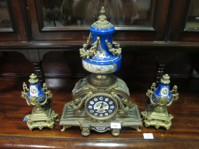 A FRENCH GILT BRASS AND PORCELAIN THREE PIECE CLOCK SUITE the rectangular arched case with