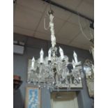 A CONTINENTAL CUT GLASS TWELVE LIGHT CHANDELIER hung with faceted chains and pendant drops