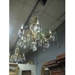 A CONTINENTAL GILT BRASS FIVE BRANCH CHANDELIER the leaf cast scroll arms hung with pendant