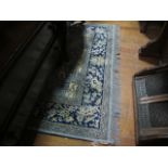 A PAIR OF WOOL RUGS each with a light blue ground decorated with flowerheads,