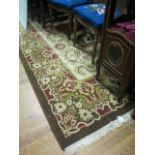 A WOOL RUG the light brown and beige ground with central floral panel within a conforming border