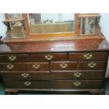 A STAINED BEECHWOOD LOWBOY the rectangular top above an arrangement of seven drawers with brass