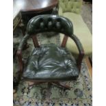 A MAHOGANY AND HIDE UPHOLSTERED SWIVEL OFFICE CHAIR the deep button upholstered back and seat with