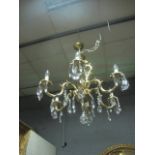 A CONTINENTAL GILT BRASS FIVE BRANCH CHANDELIER the leaf cast scroll arms hung with pendant drops