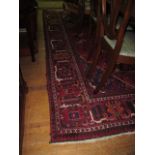 A GOOD BOKHARA WOOL RUG the wine ground with central floral panels within a conforming border 230cm