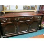 A STAINED BEECHWOOD SIDEBOARD the rectangular top above two frieze drawers and cupboards and