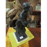 A BRONZE FIGURE modelled as a female tennis player shown standing on a marble base 40cm high